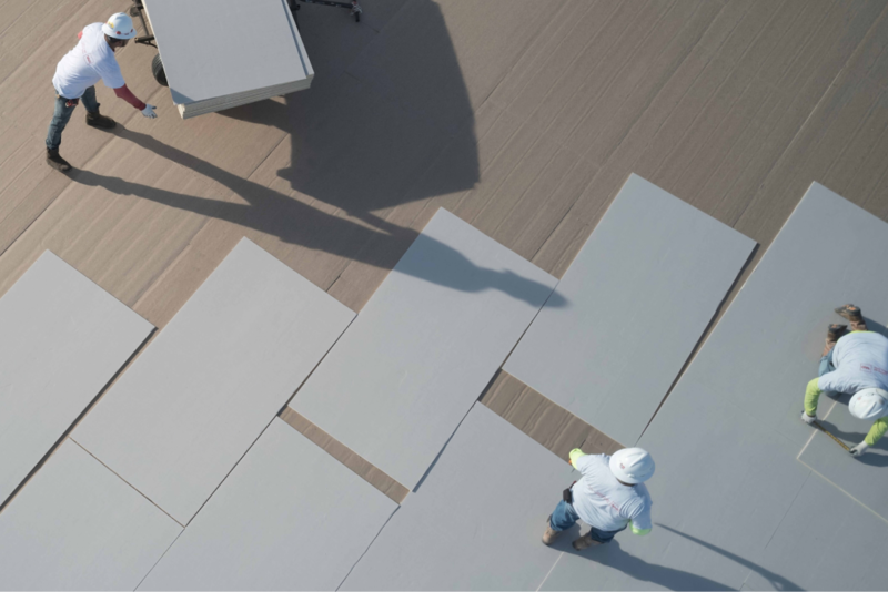 Three GAF contractors laying down and aligning TCPP-free NH polyiso products
