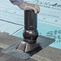 Contractor firming pushing cap down on Master Flow Pivot roof boot by GAF.